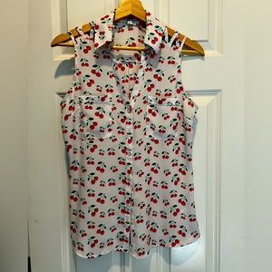Sleeveless white blouse with whimsical cherry print.  Size woman’s SMALL
